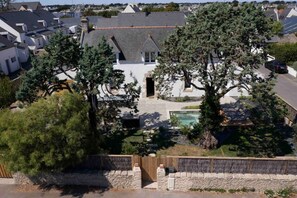 A residential property with a swimming pool, a wooden deck, and a stone wall.