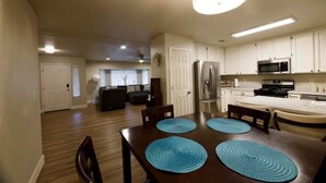 A modern kitchen with white cabinets, a stainless steel refrigerator, and a microwave.