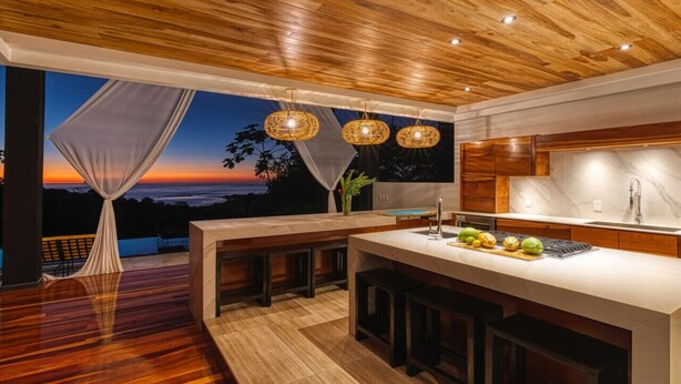 A modern kitchen with a large island, wooden ceiling, and a view of the sunset. - BEAUTY OF COSTA RICA STUNNING VIEW (Uvita)