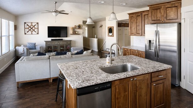 A modern kitchen with wooden cabinets, a stainless steel refrigerator, and a built-in dishwasher. - Sleeps 16 • Family Retreat Near BYU and UVU• Spacious 6BR Home,perfect for group (Orem)