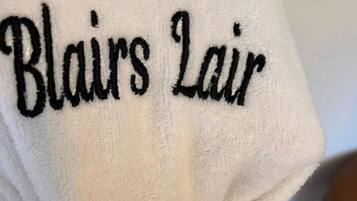 A towel with embroidered text reading "Blairs Lair".