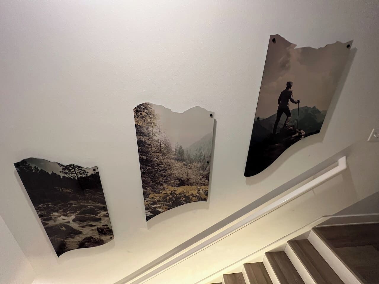 A staircase with three framed photographs on the wall.