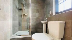 Ein modernes Badezimmer mit einer Duschkabine, einer Toilette und einem Waschbecken.