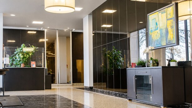 Eine moderne Lobby mit Empfangstresen, Kamin und großem, abstrakten Gemälde.