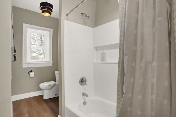 A bathroom with a toilet, a shower, and a bathtub.
