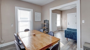 A dining area with a wooden table, chairs, and a blue sofa. - The village (Indianapolis)