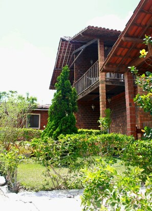 Stunning two-story residence with a balcony and lush green surroundings.