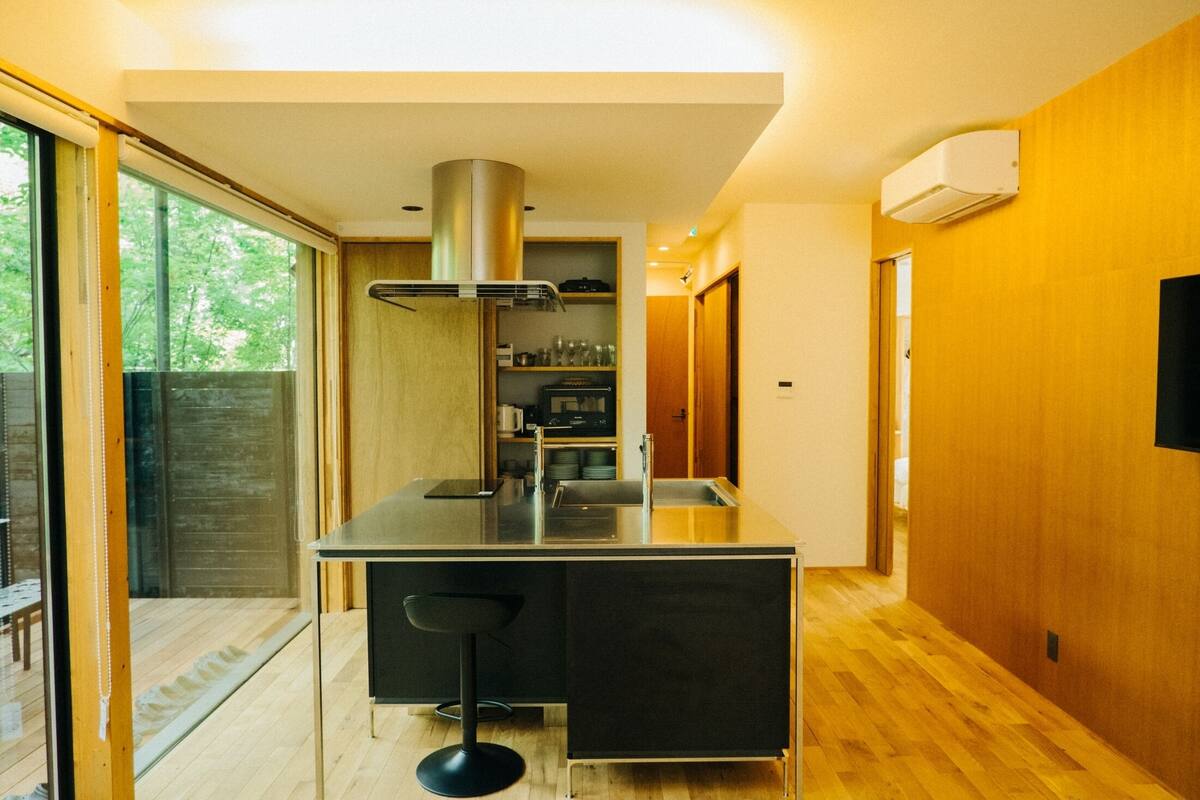 A modern kitchen with a built-in stove, a bar counter, and a large window.