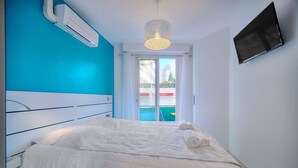 A bedroom with a bed, white bedding, a ceiling light fixture, and a TV on the wall. - 2 PIECES MODERNE 300 m plages Croisette A1B238 (Cannes)