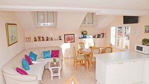 A compact living space with a sofa, dining table, and kitchen area.