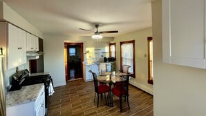A spacious kitchen with a dining area, wooden flooring, and a ceiling fan. - Hidden Gem right in the city of Boston! (Boston)