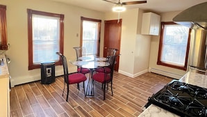 A kitchen with a dining table, chairs, a ceiling fan, and a stove. - Hidden Gem right in the city of Boston! (Boston)