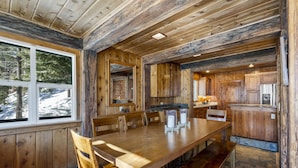A wooden interior with a large dining table, chairs, and a kitchen area. - Rivendell - Escape at Historic Home in Olympic Valley, Near Village, Golf, and Minutes to Tahoe (Olympic Valley)