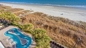 Een strandresort met een zwembad, toegang tot het strand en uitzicht op de oceaan.