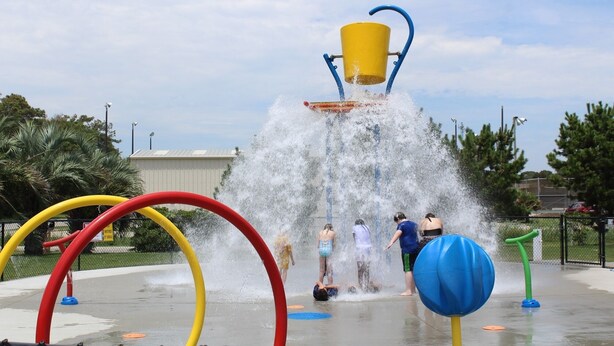 Un área de juegos acuáticos con múltiples chorros de agua y estructuras de juego coloridas.
