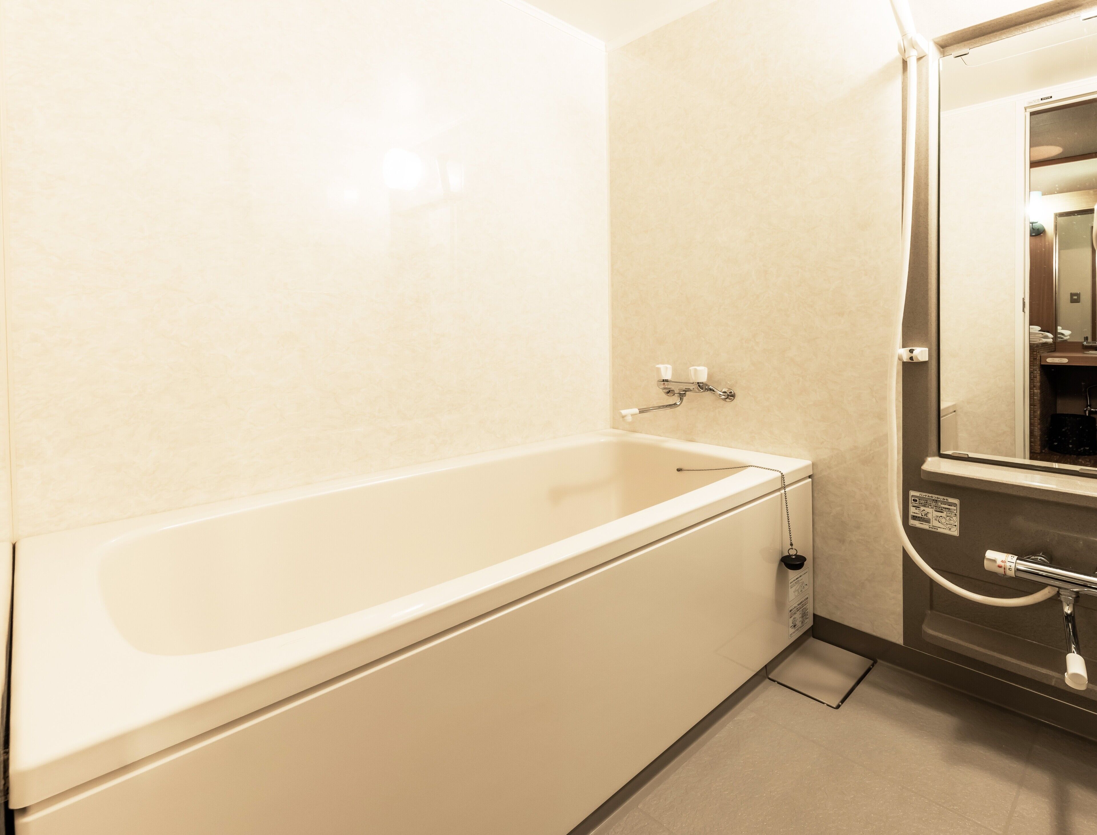 Un baño de hotel estándar con bañera, ducha y espejo.