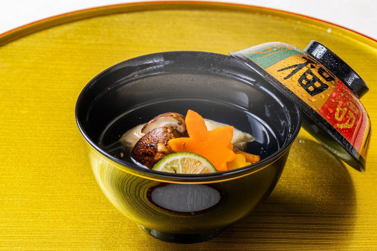 A bowl of food with a decorative item on a yellow surface.