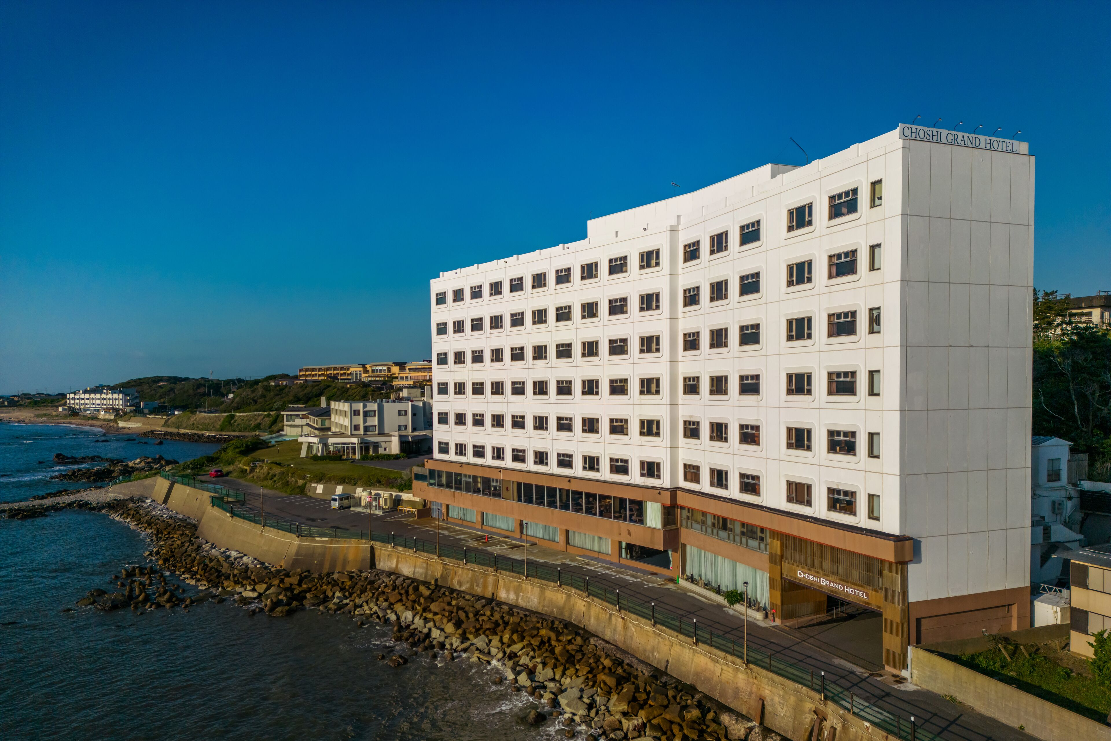 Un hotel de varios pisos con fachada blanca, situado cerca de la costa.