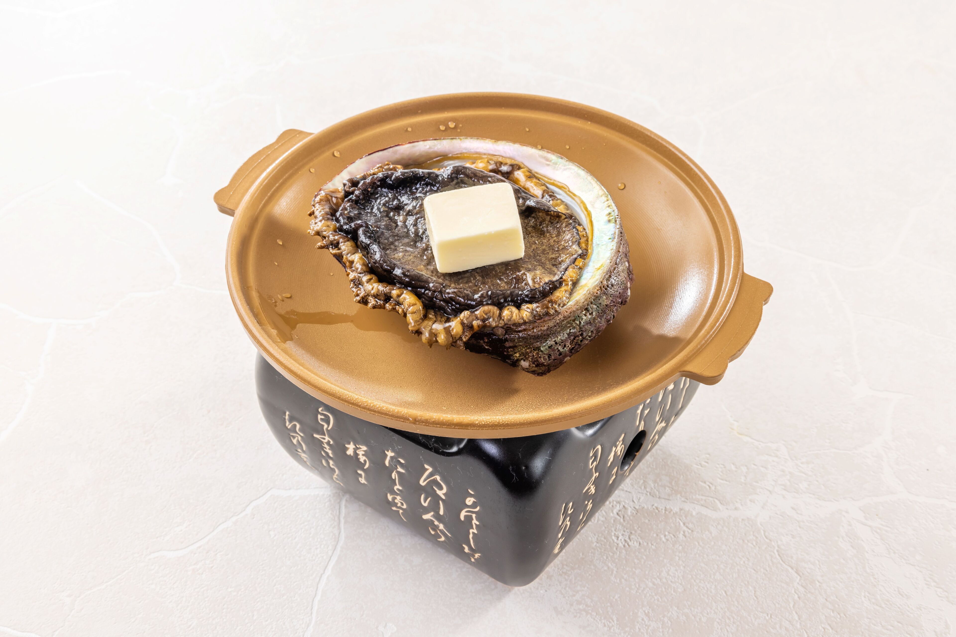 A container with a lid, a piece of food, and a block of butter on top.