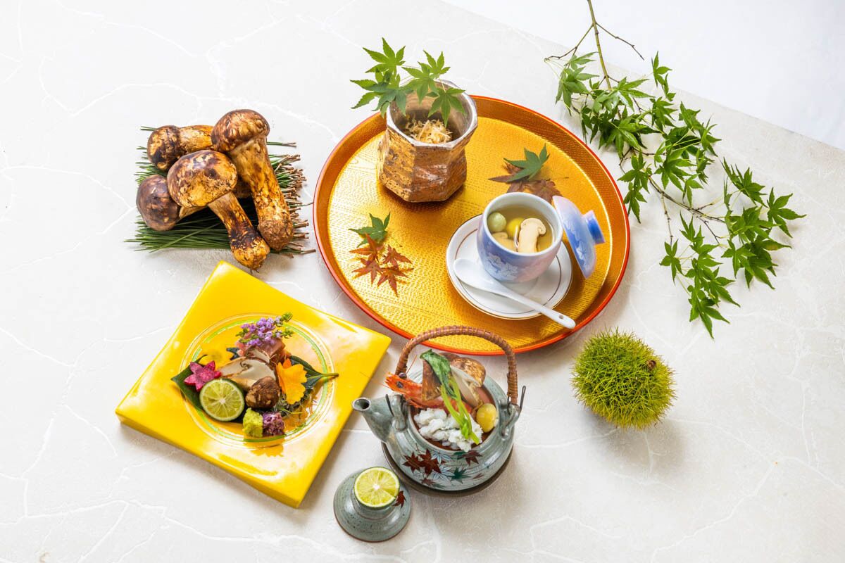 Une table dressée avec une variété de plats, notamment un poulet rôti, un bol de soupe et une assiette de salade.