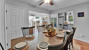 A dining area with a wooden table set for six, surrounded by chairs. A ceiling fan is visible above the table. - The Easy St Chalet in Albrightsville (Albrightsville)