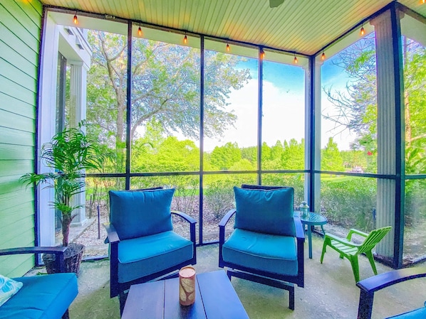 A covered patio with two blue chairs, a table, and a potted plant. - Beautifully updated large family condo with King suite - 15 minutes to Disney (Davenport)