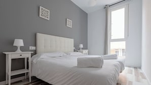 Ein Schlafzimmer mit einem großen Bett, Nachttischen und einem Fenster.