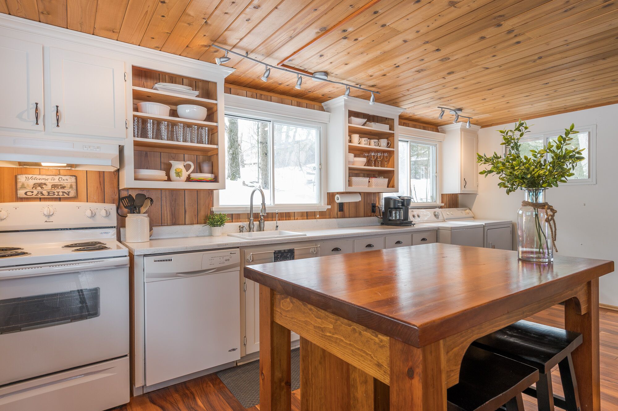 Een keuken in chaletstijl met houten kastjes, een fornuis en een eettafel.