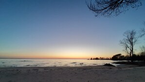 A beach with a clear sky and calm water. - Cozy Beachfront Cottage (North Bay)