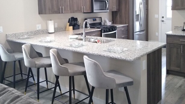 A modern kitchen with a large island, bar stools, stainless steel appliances, and pendant lighting. - Book NOW for Summer Events! Located in downtown Salida! (Salida)