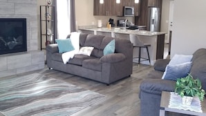 A modern living room with a grey sofa, a coffee table, and a fireplace. - Book NOW for Summer Events! Located in downtown Salida! (Salida)