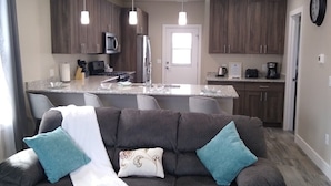 A modern kitchen with dark wooden cabinets, a central island, and pendant lighting. - Book NOW for Summer Events! Located in downtown Salida! (Salida)