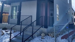 A modern two-story house with a covered front porch, a visible number '325' on the side, and a snow-covered ground. - Book NOW for Summer Events! Located in downtown Salida! (Salida)