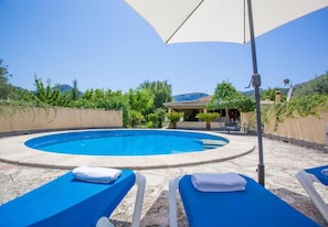 A pool area with blue lounge chairs and a white umbrella. - 3 bedroom country house with private pool and barbecue (Pollensa)