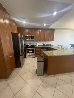 Enjoy cooking and dining in this well-equipped kitchen with a central island, sink, and stainless steel appliances.