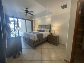 Relax in this stylish room with a large bed, ceiling fan, and balcony access.