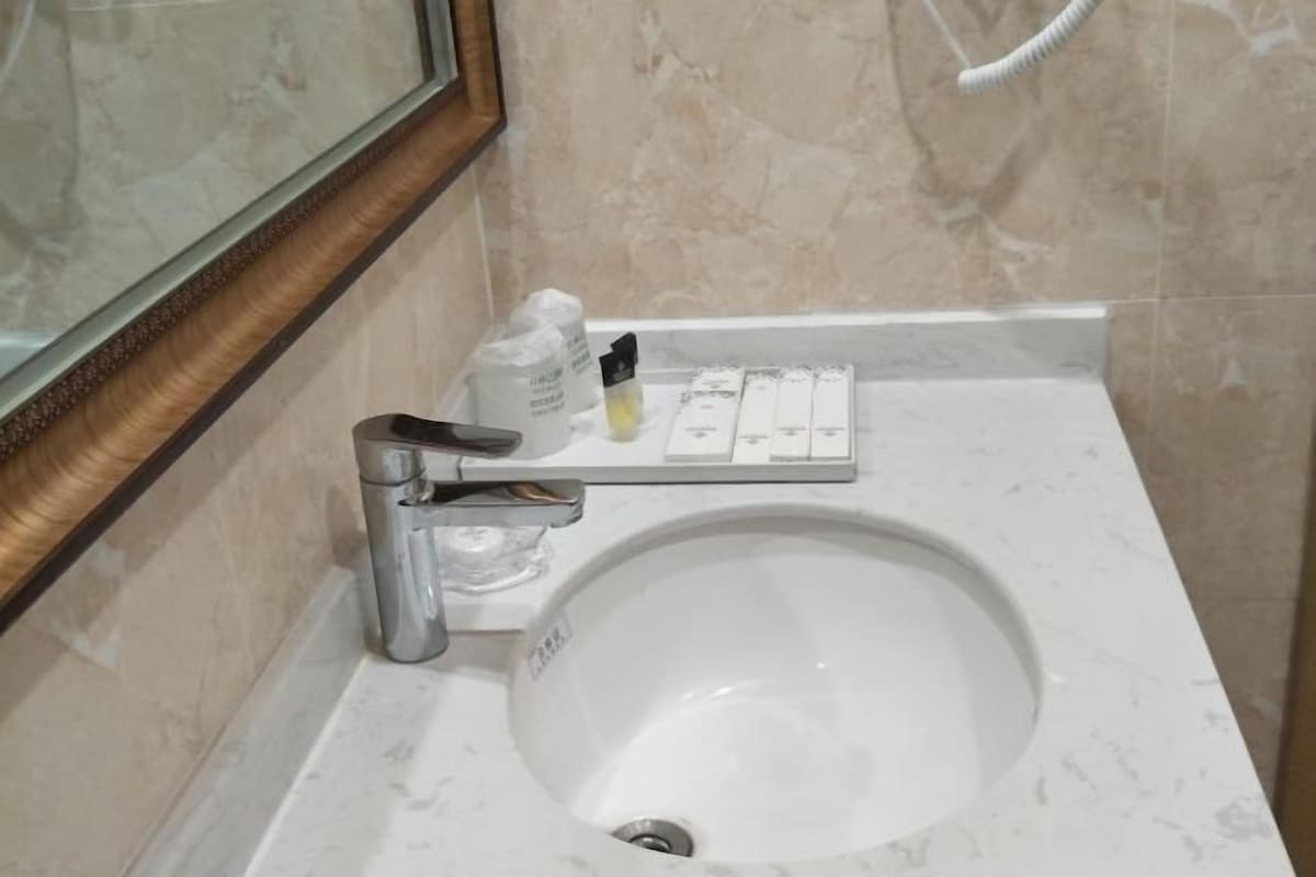 A bathroom with a white sink, a mirror, and a towel rack.