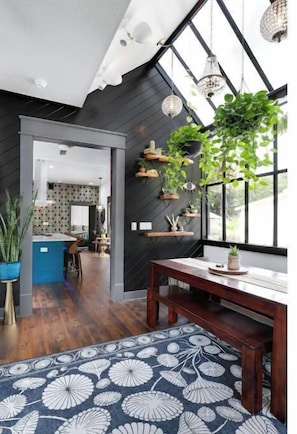 A modern kitchen with dark wood cabinets, a blue island, and a view into the dining area.