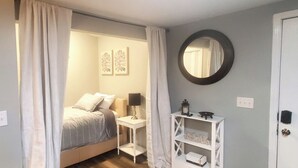 Una camera da letto con un letto, un comodino, una lampada e una mensola con il cartello 'RELAX'.