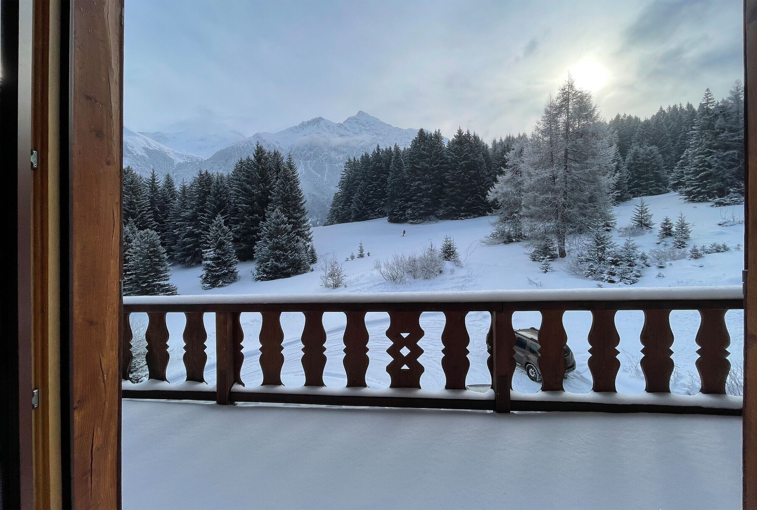Eine verschneite Berglandschaft mit einem Holzbalkon.