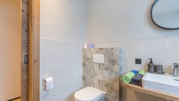 Un baño con inodoro, ducha y lavamanos.