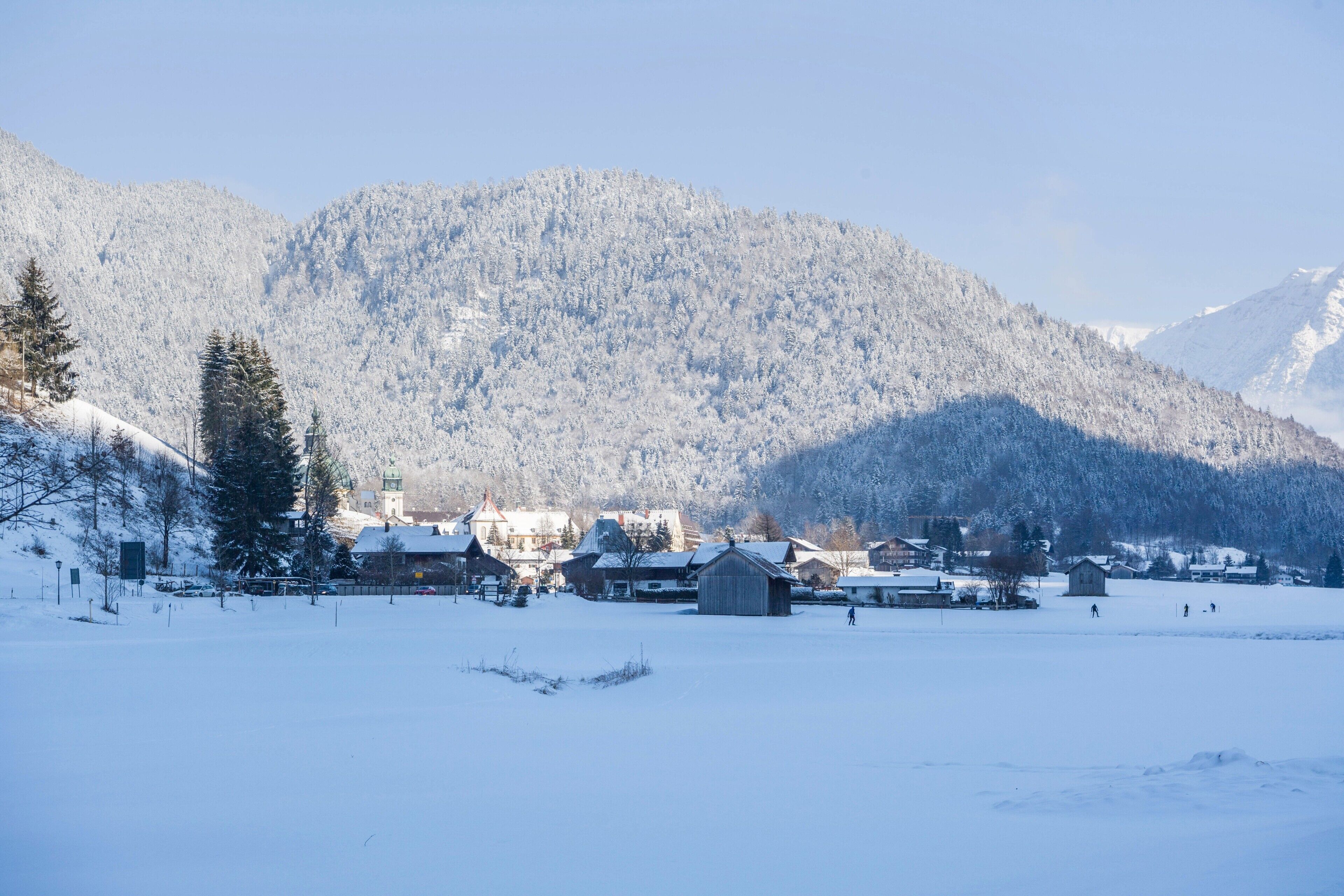 A snow-covered village with buildings and a mountain backdrop.