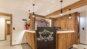 Una recepción con acabado de madera y un letrero de neón que dice 'Luisalle'.