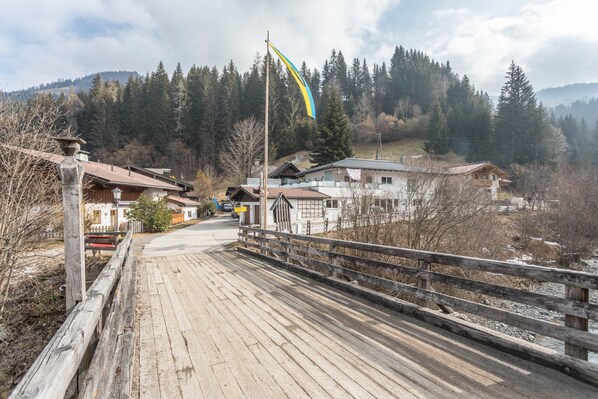 Un pont en bois qui mène à une rangée de maisons, avec un drapeau en arrière-plan.