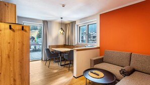Una habitación moderna con un escritorio de madera, un sofá y un comedor.