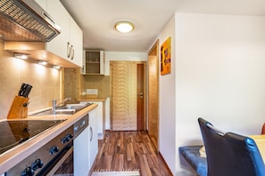 Una cocina moderna con estufa integrada, un lavamanos y suelo de madera.