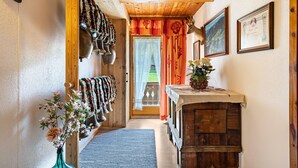 A wooden hallway with a bench, a vase of flowers, a bell, and a framed certificate on the wall. - Apartment 'Unterlehenhof N' with Mountain View, Balcony and Wi-Fi (Zell am Ziller)