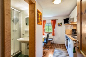 Cuina compacta amb rentapelats, fogó i finestra amb cortines.