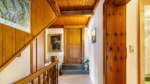 A wooden staircase leading to a door with a painting above it. - Apartment 'Unterlehenhof N' with Mountain View, Balcony and Wi-Fi (Zell am Ziller)