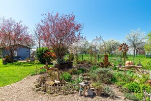Un jardín con diversas plantas y una estatua decorativa de un ciervo.